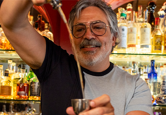 bar and business owner mixing drinks at bar.